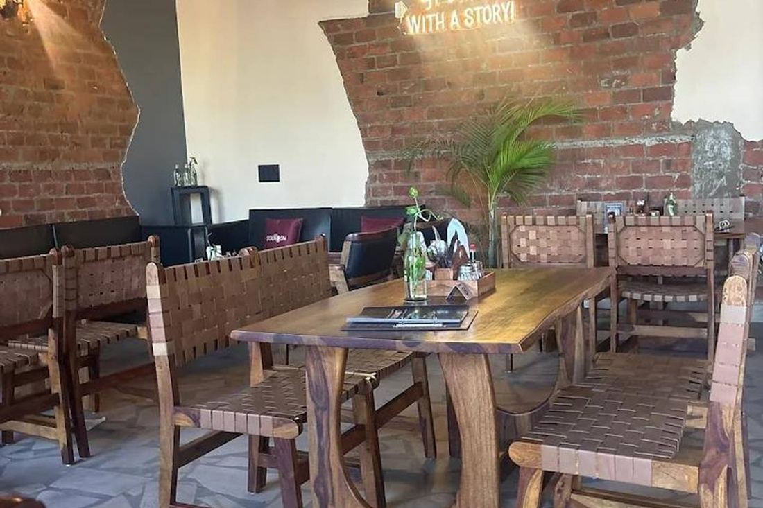 Indoor seating with exposed brick wall and woven wooden chairs