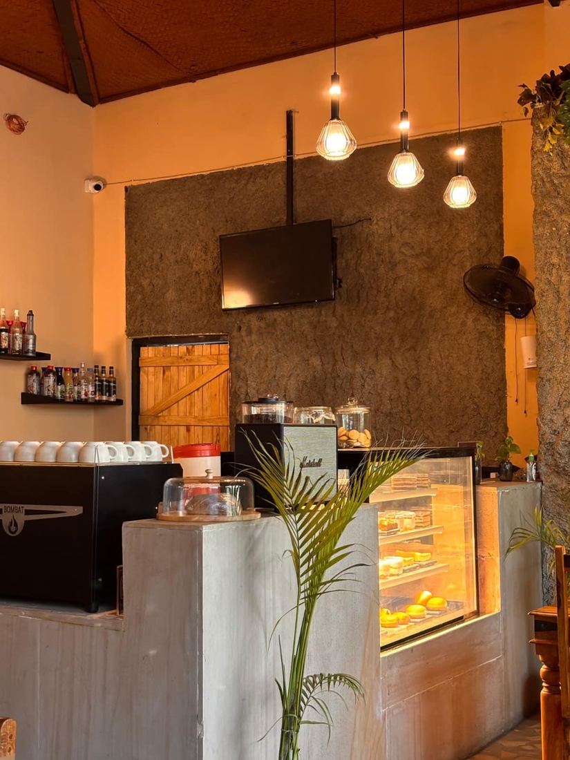 The coffee counter with espresso machine, dessert display and pendant bulbs