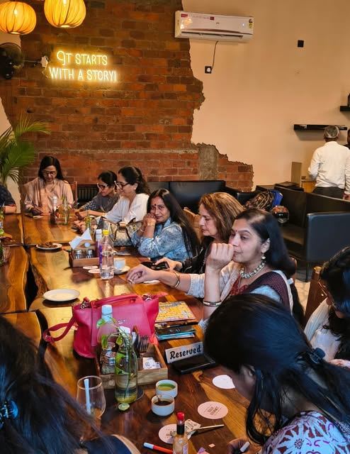 A long table of guests under the 'It starts with a story' neon sign